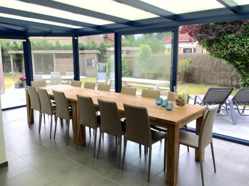 Cottage Fleuri في كوكسيجدي: طاولة طعام وكراسي خشبية في فناء