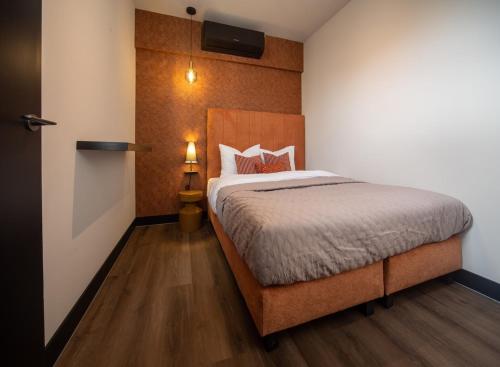 ein Schlafzimmer mit einem großen Bett mit einem hölzernen Kopfteil in der Unterkunft De Oranjestad - In de winkelstraat in Breda