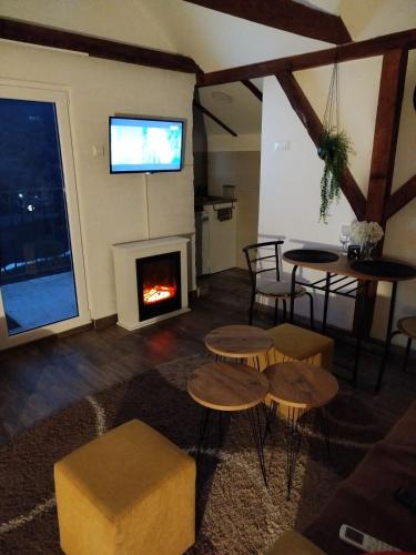 a living room with a fireplace and a table and chairs at Vila Lena in Međuvršje