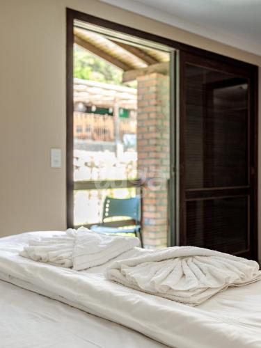 a large white bed in a room with a window at Vieira Eco Inn – Master Suite Vanderleia in Orleans
