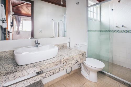 a bathroom with a sink and a toilet and a mirror at Residencial Portoveleiro in Cabo Frio