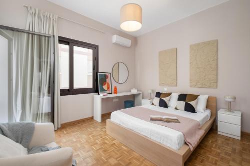 a white bedroom with a bed and a chair at Casa Centrale by Nomads in Paphos City