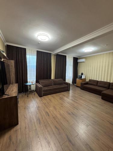 ein Wohnzimmer mit zwei Sofas und einem Fernseher in der Unterkunft Унікальні двокімнатні апартаменти класу ЛЮКС in Solotschyn