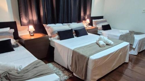 ein Hotelzimmer mit 3 Betten und 2 Lampen in der Unterkunft Casa ampla perto do Aeroporto de Viracopos in Viracopos