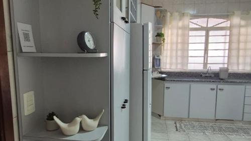 Eine Küche mit einem Kühlschrank und einigen Schuhen auf einem Regal. in der Unterkunft Casa ampla perto do Aeroporto de Viracopos in Viracopos