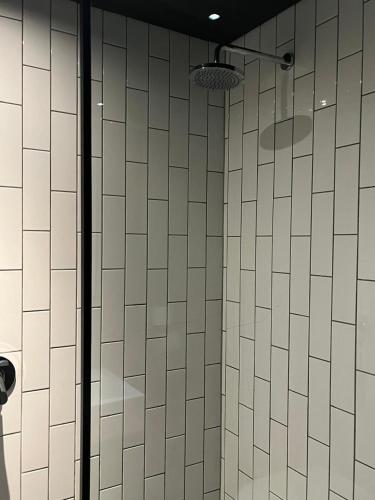 a bathroom with a shower with white tiled walls at Apartment with Mountain views Wex1 in Cape Town