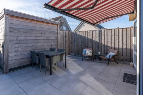 un patio avec une table et des chaises et une clôture dans l'établissement Hello Zeeland - Piet Mondriaanstraat 4a, à Domburg