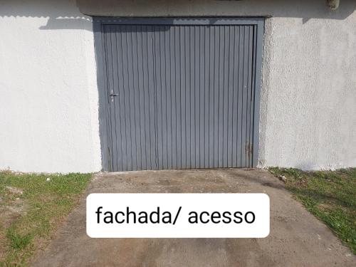 ein Garagentor mit einem Schild, auf dem „faciada assos“ steht in der Unterkunft Kitnet geminada próximo da praia in Torres