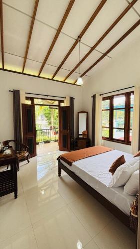 a large bedroom with a large bed and a desk at Green Villa Matale in Palapatwela