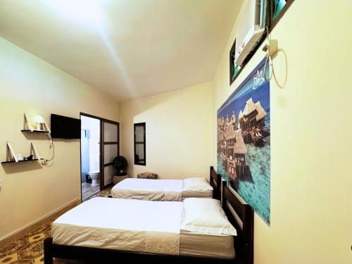 Habitación con 2 camas y un cartel en la pared. en Tombo Beach Yoga Bem-estar, en Guarujá