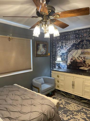 a bedroom with a ceiling fan and a bed and a chair at Splendid Room in House 10 mins to Airport in Saint Louis
