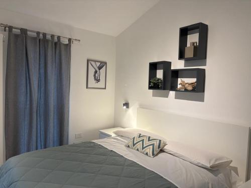 a bedroom with a bed and a blue curtain at Casina al Lago in Lavena Ponte Tresa