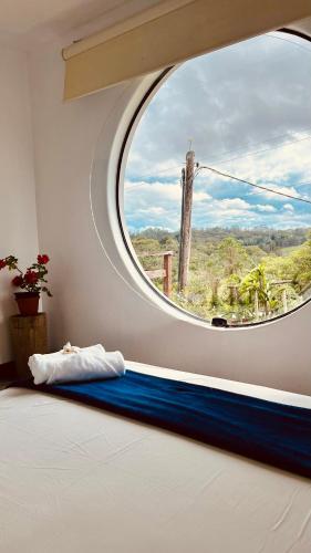a bedroom with a large circular window and a bed at Recanto UAI in Piedade