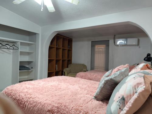 a bedroom with two beds and a pink blanket at la casa de la tia Lucita in Ciudad Juárez