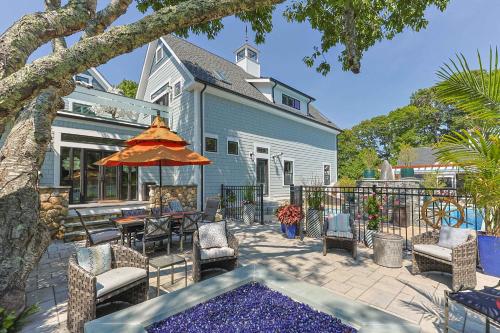 een terras met een tafel, stoelen en een parasol bij Heated Pool Outdoor Kitchen Luxury Living in Harwich
