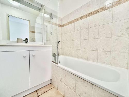 a bathroom with a white tub and a sink at Appartement cosy 3 pièces pour 6 pers. - Serre Chevalier - FR-1-330F-26 in Serre Chevalier