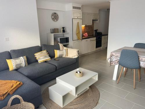 un salon avec un canapé bleu et une cuisine dans l'établissement Centrally located and comfortable apartment - Daubenhorn 32, à Arni Alp