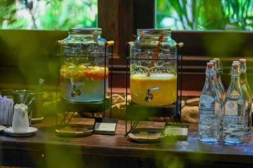 two glass jars filled with fruit and drinks on a table at Panhou Retreat in Ha Giang