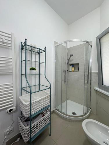 a bathroom with a shower and a shelf with towels at IELLE Suite Brutia in Cosenza