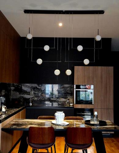 a kitchen with a table and some chairs and a kitchen with black at Le Galeriste - parking inclus in Reims