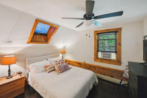 ein Schlafzimmer mit einem Bett und einem Deckenventilator in der Unterkunft Cushing Home - Family Cabin Near Wachusett Mtn home in Ashburnham