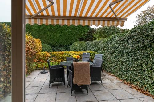 a patio with a table and chairs and a fence at Hello Zeeland - JW Schuurmanstraat 116 in Domburg