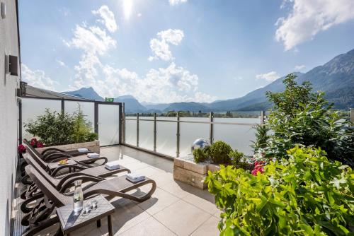 uma varanda com cadeiras e vista para as montanhas em AVALON Hotel Bad Reichenhall em Bad Reichenhall