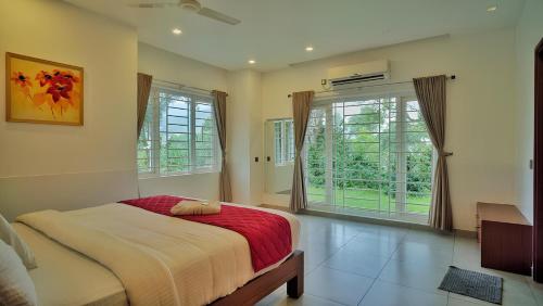 une chambre avec un lit et une grande fenêtre dans l'établissement Kanthalloor Moments, à Kanthalloor