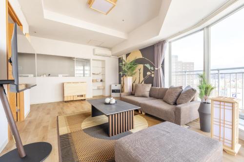 a living room with a couch and a table at Cozy Stay Sapporo Central in Sapporo