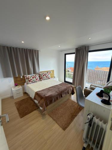 a bedroom with a bed and a view of the ocean at Vivenda Silva in Seixal