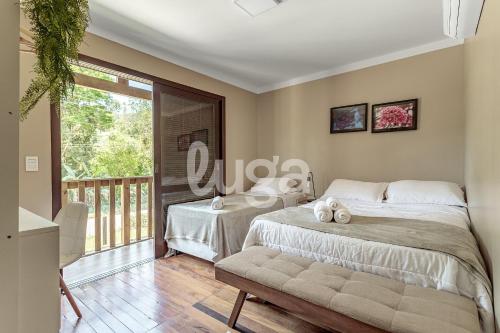 a bedroom with a bed and a balcony at Vieira Eco Inn – Deluxe Suite Thiago #3 in Orleans