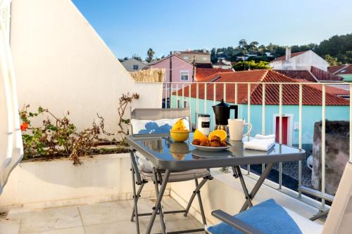 a table with a bowl of fruit on a balcony at River & Beach Apartment near Lisbon in Trafaria