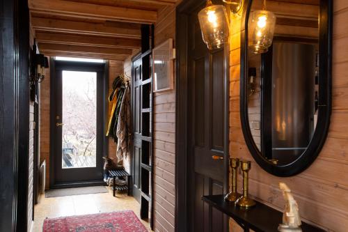 - un couloir d'une maison avec un miroir et une porte dans l'établissement Very cozy cottage, Rauðará, with sauna, à Gilsbakki