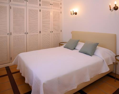 a bedroom with a large white bed with two pillows at Casa do Poço in Faro