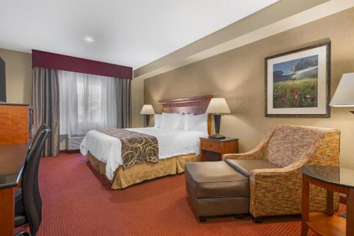 a hotel room with a bed and a chair at Best Western Plus Canyon Pines in Ogden