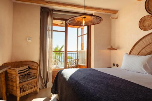 哈维亚Nomad Hotel - Xábia Port的一间带床、窗户和椅子的卧室