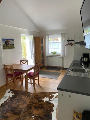 a kitchen with a table and chairs and a kitchen with a sink at Allgäu- Ferienwohnung mit Hund in Oberreute