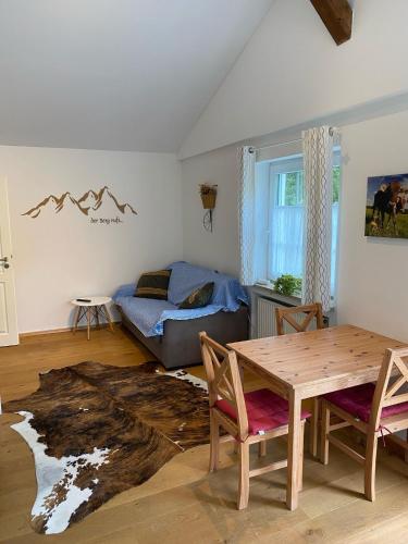 a living room with a table and a couch at Allgäu- Ferienwohnung mit Hund in Oberreute
