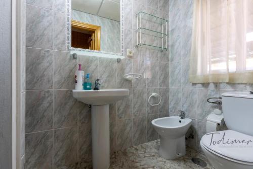 ein Badezimmer mit Waschbecken, Toilette und Spiegel in der Unterkunft Todimer casa roble in Carchuna