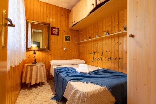 1 Schlafzimmer mit 2 Betten an einer Holzwand in der Unterkunft Todimer casa roble in Carchuna