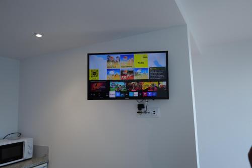a flat screen tv hanging on a wall at Vivenda Silva in Seixal
