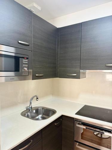 a kitchen with a sink and a microwave at Apartamento Cúrcuma - Vigo Centro in Vigo