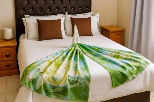 a bed with a colorful blanket on top of it at EE Maison Bed and Breakfast in Francistown