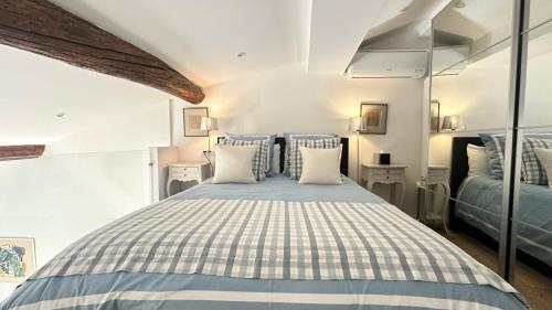 芒通Le cap的卧室里有一张床，上面有蓝白色的枕头