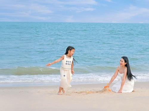 two women playing in the sand on the beach at SO/ Sofitel Hua Hin in Cha Am