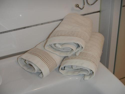 due rotoli di asciugamani seduti sopra un bancone di Sonniges Modernes Appartement Höhenberg a Colonia