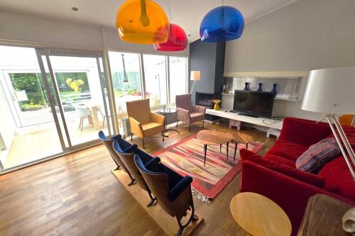 a living room with a red couch and chairs at Hello Zeeland - Margrietenlaan 5 in Oostkapelle