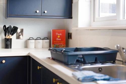 eine Küchentheke mit einer Spüle und einem blauen Schrank in der Unterkunft Durham WorkNest in Burnhope