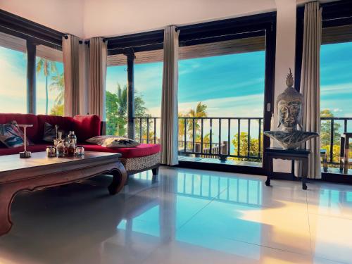 ein Wohnzimmer mit einem roten Sofa und großen Fenstern in der Unterkunft SeaView Villa Tropicana in Salad Beach