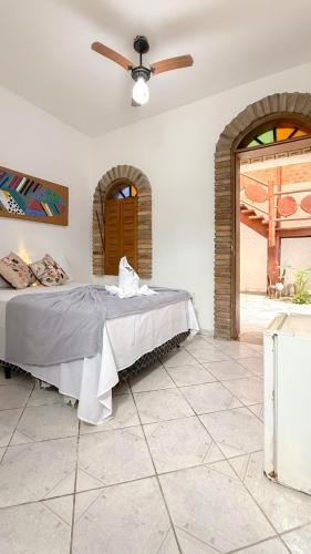 a bedroom with a bed and a ceiling fan at Pousada Maken Hary - Centro in Arraial d'Ajuda